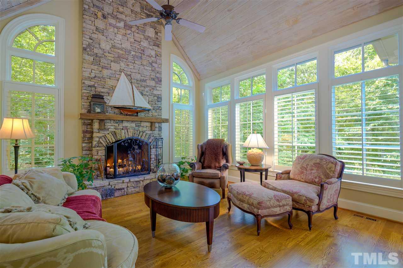 317 Homestead Drive Cary, NC 27513 - Photo 7 of 30 a living room with furniture a fireplace a lamp and a large window