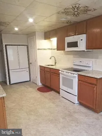 a kitchen with granite countertop a sink and white cabinets