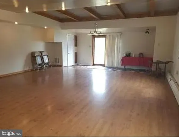 a view of empty room with wooden floor and chair