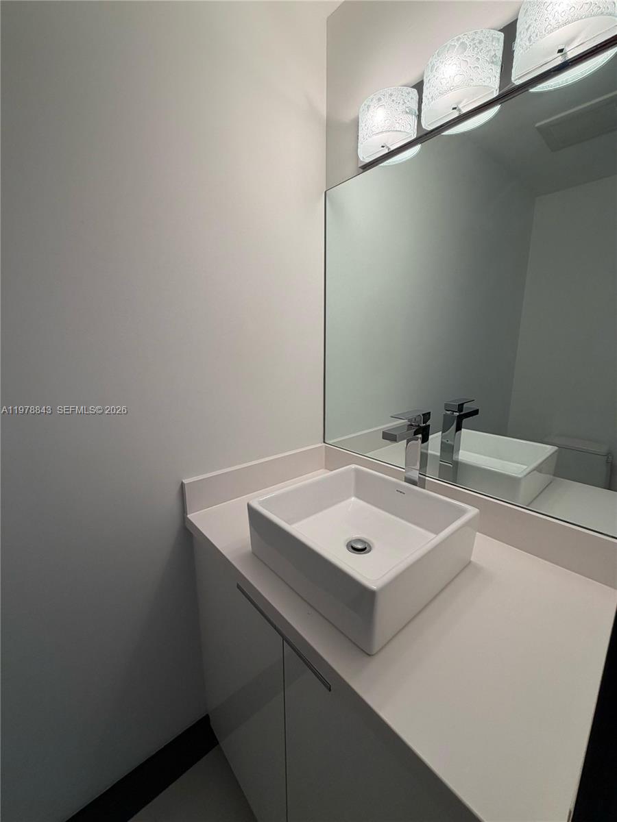 2699 Tigertail Avenue, Unit 14 Miami, FL 33133 - Photo 15 of 28 a bathroom with a sink vanity and a toilet