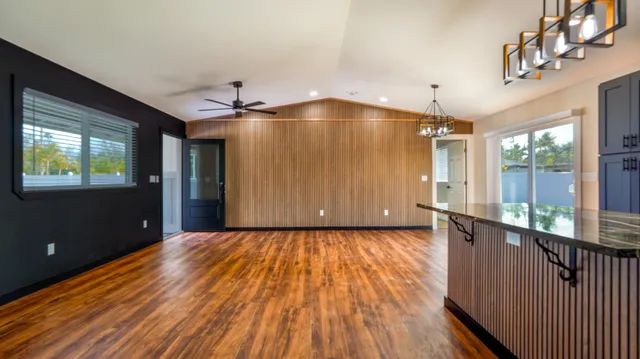 a view of a hallway with wooden floor and a ceiling fan