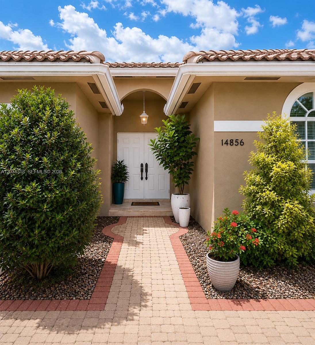 14856 Southwest 179th Street Miami, FL 33187 - Photo 1 of 33 a view of a white house with a potted plant and a yard in front of it