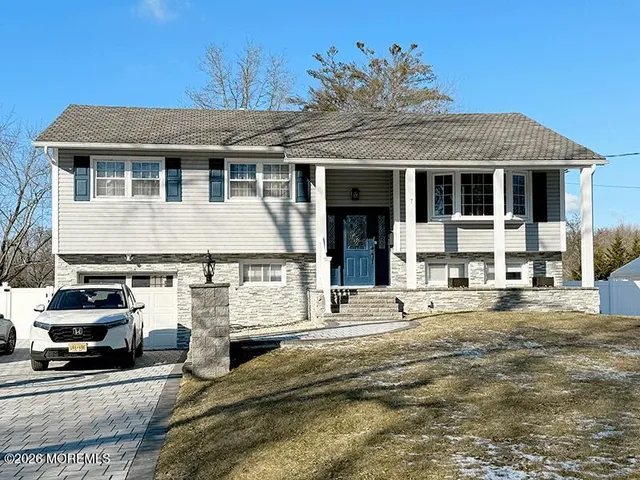 a view of a white house with large windows and a table and chairs
