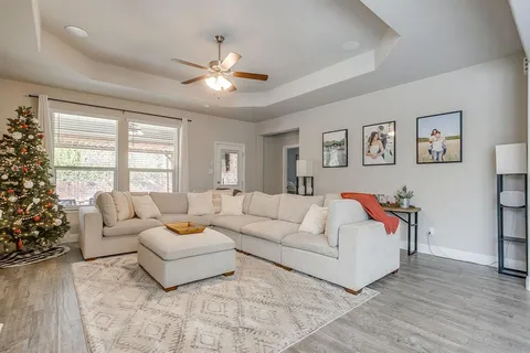 a spacious bedroom with a bed a couch and a chandelier