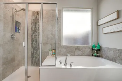 a spacious bathroom with double vanity a mirror a vanity and a bathtub