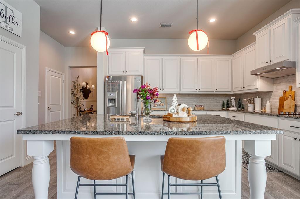 5821 Rendyn Court Midlothian, TX 76065 - Photo 6 of 30 a kitchen with stainless steel appliances granite countertop a kitchen island a stove a cabinets a sink and a white cabinets