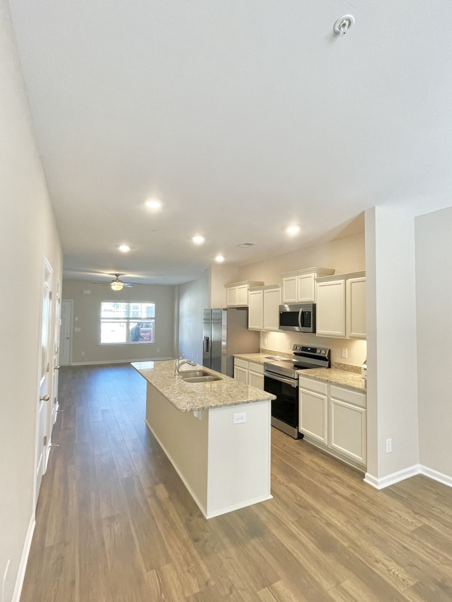 205 Addi Street Pleasant View, TN 37146 - Photo 6 of 13 a view of kitchen with kitchen island a sink wooden floor and white stainless steel appliances