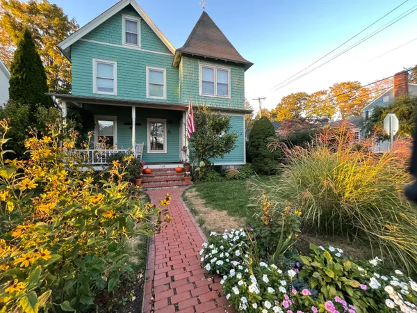 a front view of a house with a yard and potted plants