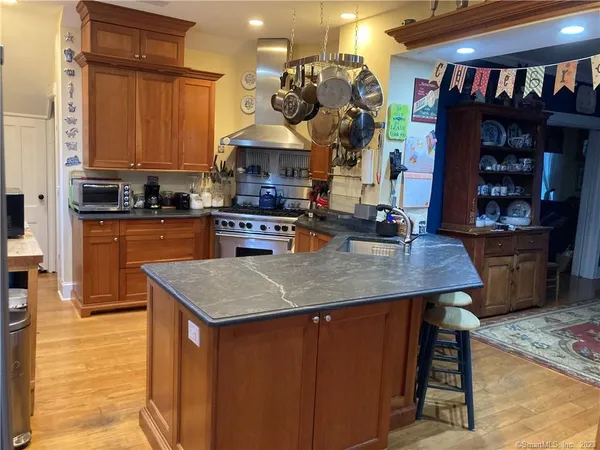 a kitchen with stainless steel appliances granite countertop a sink a stove and a wooden cabinets