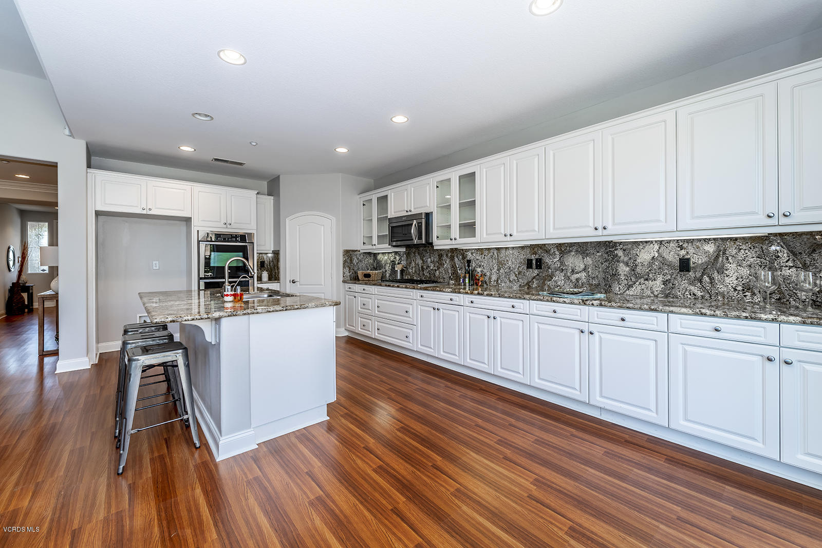 641 Riviera Court Oxnard, CA 93035 - Photo 9 of 18 a kitchen with wooden floors and white stainless steel appliances