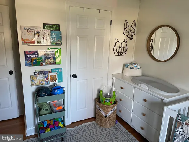 a bedroom with a bed a dresser and a book shelf