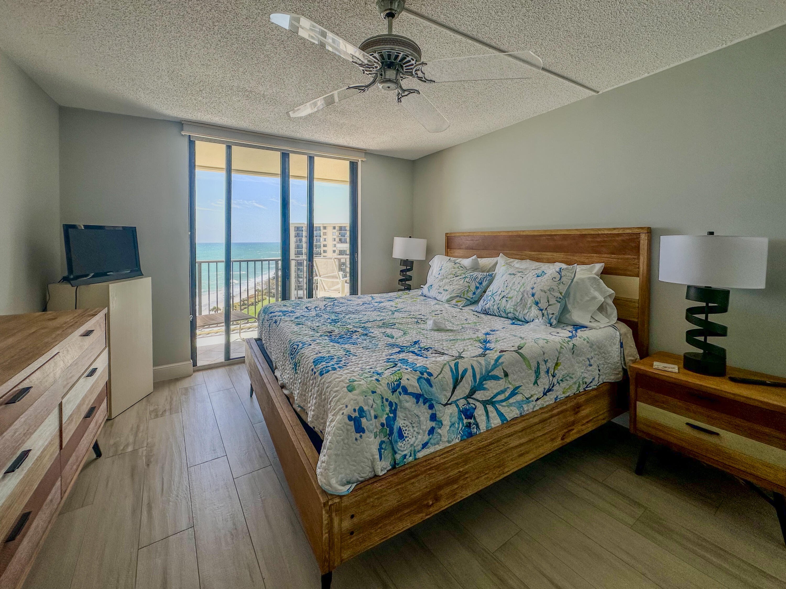 200 Ocean Trail Way, Unit 1107 Jupiter, FL 33477 - Photo 22 of 29 a bedroom with a bed and a chandelier