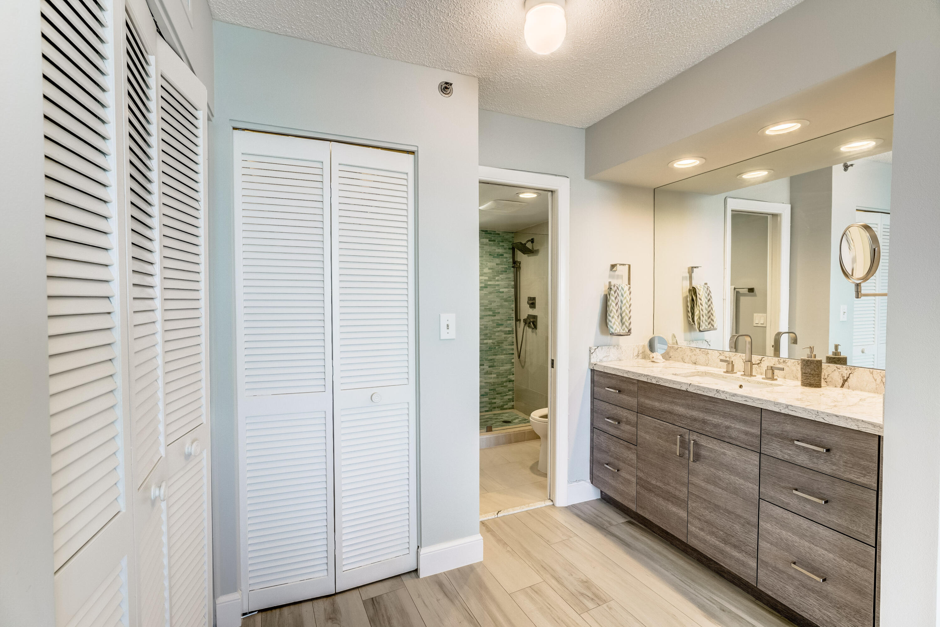 200 Ocean Trail Way, Unit 1107 Jupiter, FL 33477 - Photo 5 of 29 a bathroom with a glass door shower a sink and a mirror