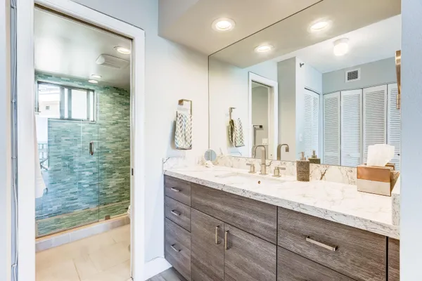 a bathroom with double vanity sink and a mirror