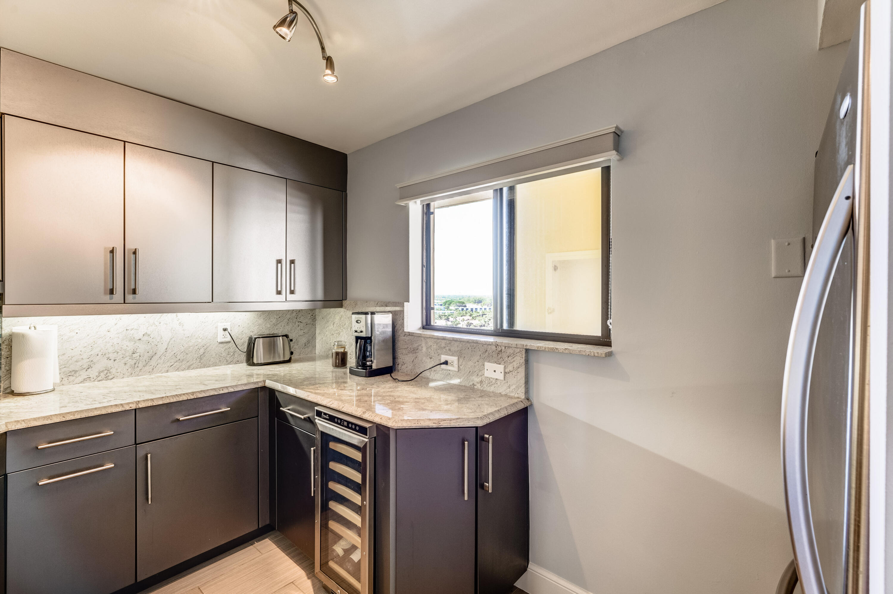 200 Ocean Trail Way, Unit 1107 Jupiter, FL 33477 - Photo 9 of 29 a kitchen with a sink stove and cabinets