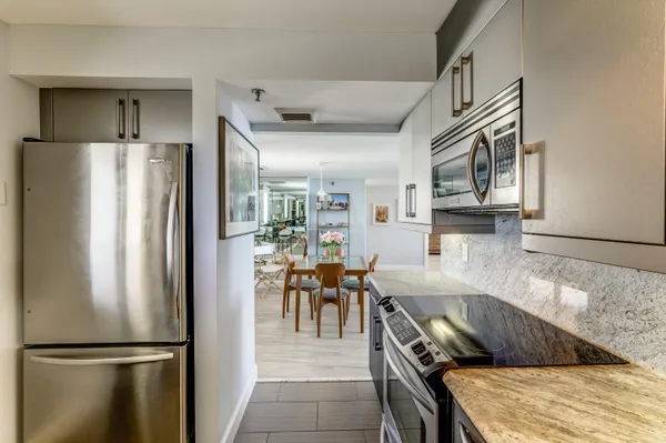 a kitchen with stainless steel appliances granite countertop a refrigerator and a stove