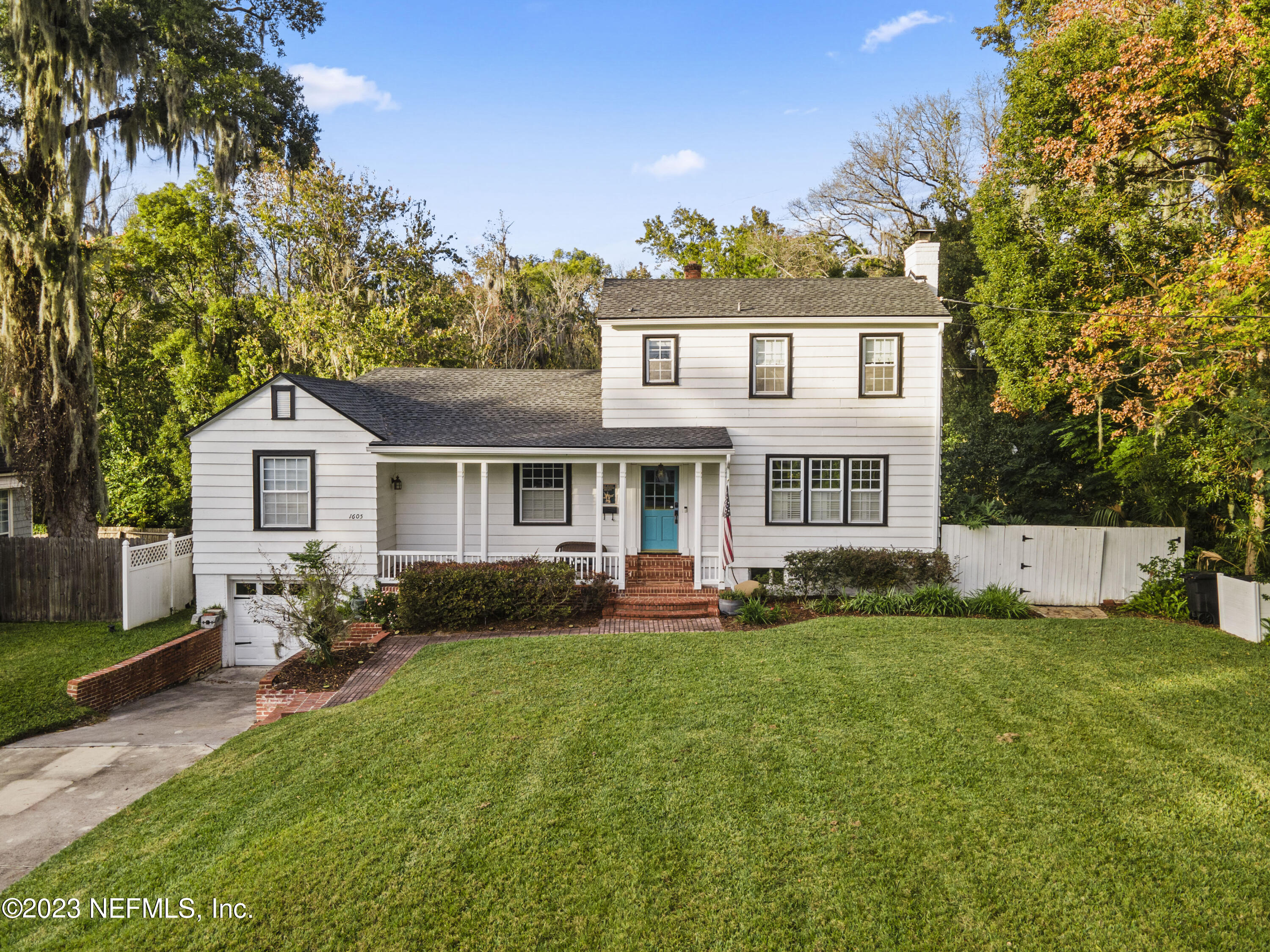 a front view of a house with a garden and trees