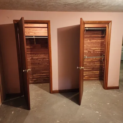 a view of an empty room with furniture and a window