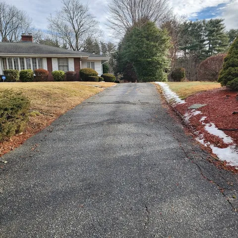 a front view of a house with a yard and trees
