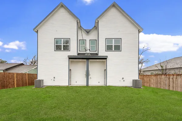 a view of a house with backyard and wooden fence