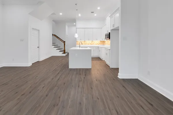 a view of a kitchen with wooden floor and a refrigerator