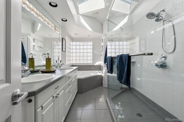 a bathroom with a double vanity sink mirror and bathtub