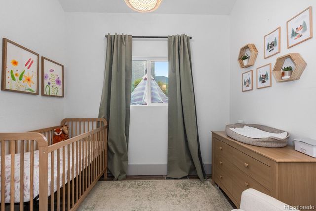 a bedroom with a baby crib and a window