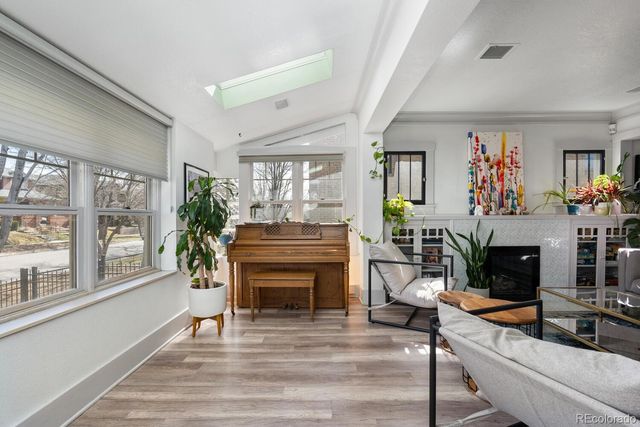 a living room with furniture a fireplace and potted plants