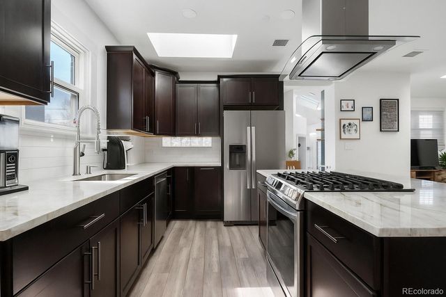 a kitchen with stainless steel appliances granite countertop a sink stove and refrigerator
