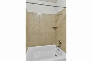 a bathroom with a tub shower and a sink