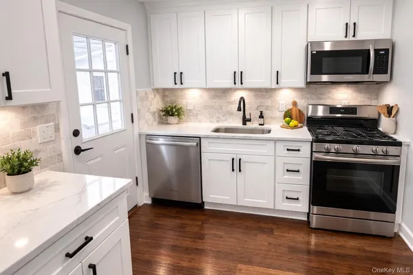 a kitchen with granite countertop a sink stainless steel appliances and cabinets