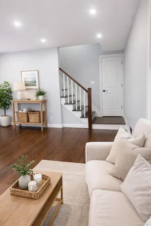 a living room with furniture and a dining table with wooden floor