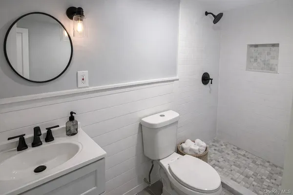 a bathroom with a sink mirror and toilet