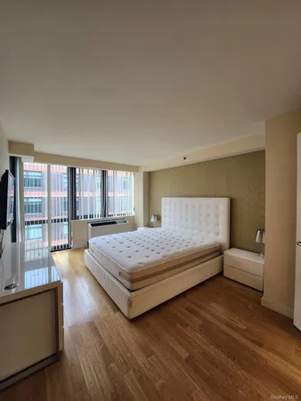 a spacious bedroom with a bed and large windows
