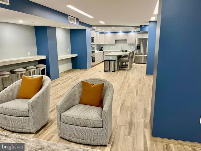 a living room with furniture and a dining table with kitchen view
