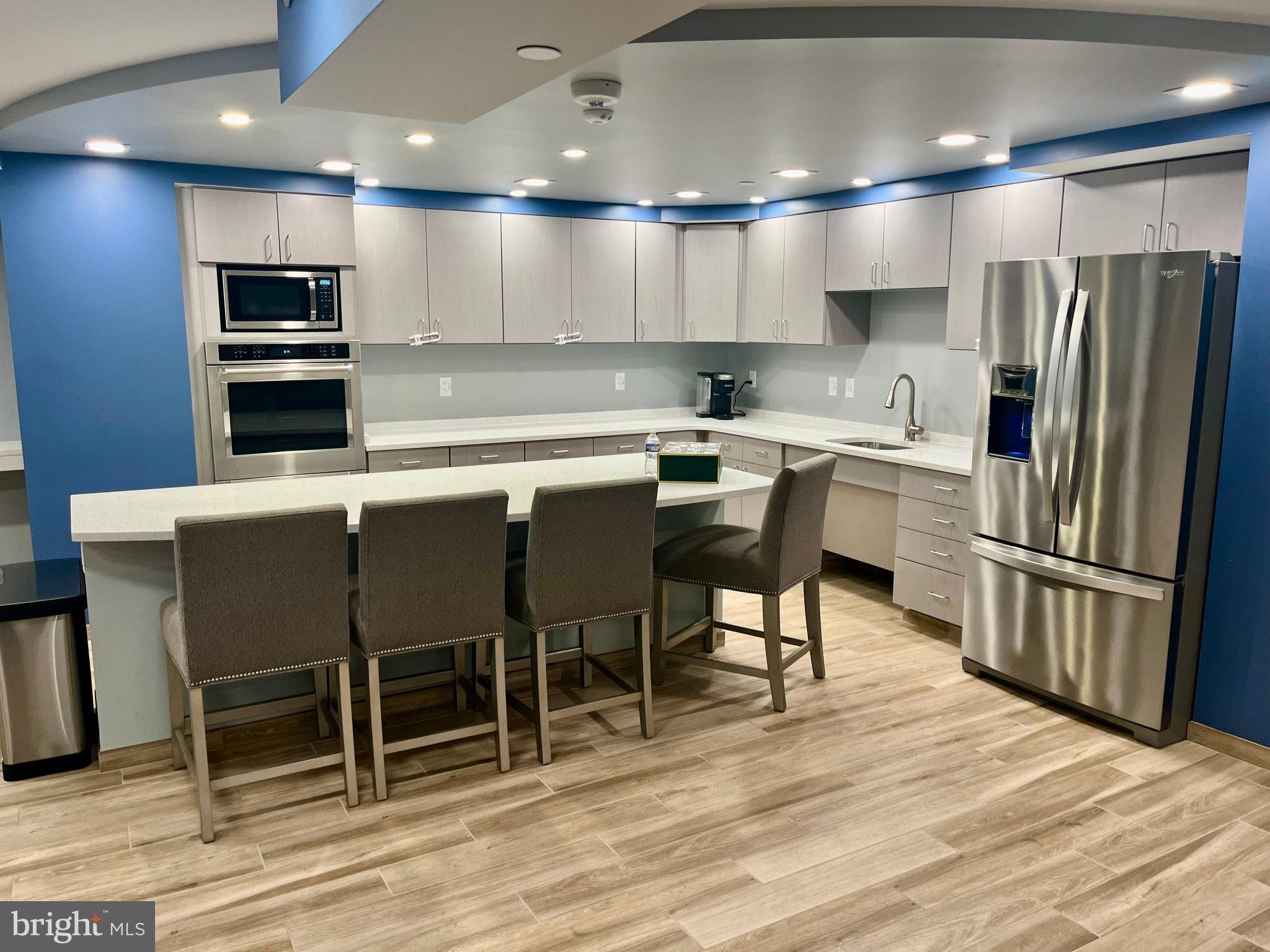 1808 Old Meadow Road, Unit 1104 McLean, VA 22102 - Photo 35 of 35 a kitchen with stainless steel appliances granite countertop a table chairs sink refrigerator and microwave