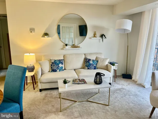 a living room with furniture a rug and white walls