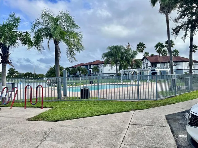 a view of a house with a yard and palm trees