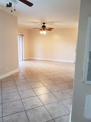 en empty room with windows and ceiling fan