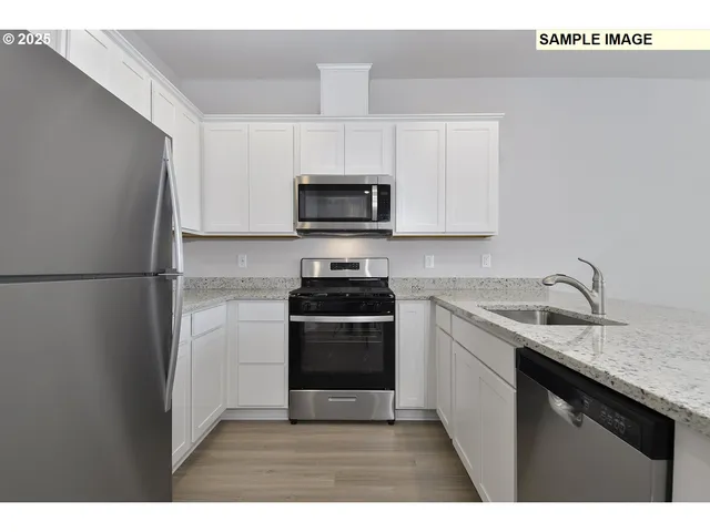 a kitchen with a sink a stove top oven and refrigerator