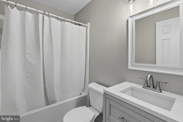 a bathroom with a sink vanity mirror and toilet