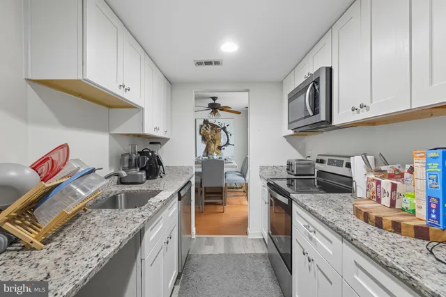 a kitchen with stainless steel appliances granite countertop a stove and a sink