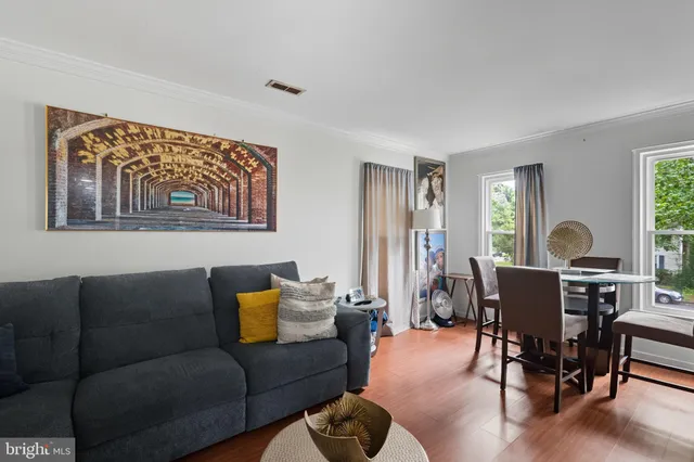a living room with furniture a wooden floor and a window