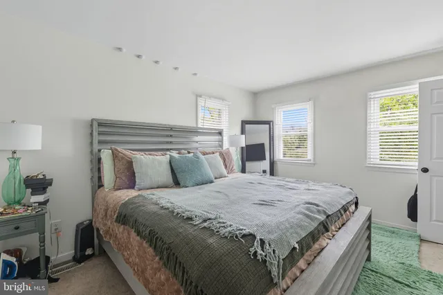 a bedroom with a bed and a potted plant on table