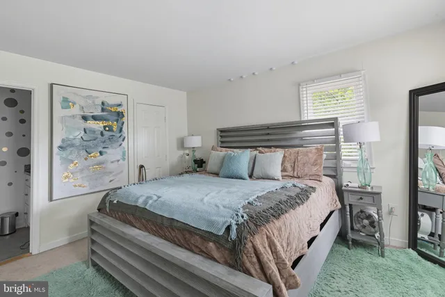 a bedroom with a bed and a painting on the wall