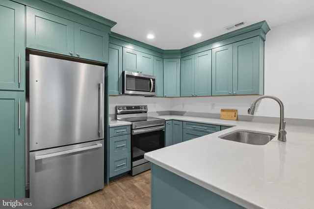 a kitchen with stainless steel appliances a refrigerator and a sink
