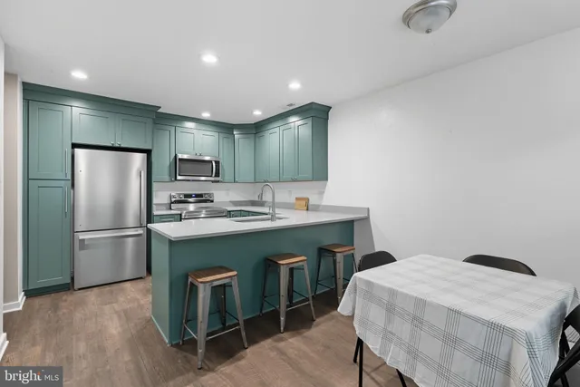 a kitchen with kitchen island a appliances a sink and a refrigerator