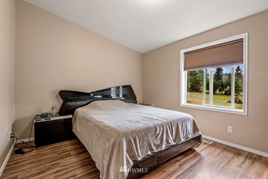 878 Oak Point Road Longview, WA 98632 - Photo 12 of 32 a bedroom with a bed and wooden floor