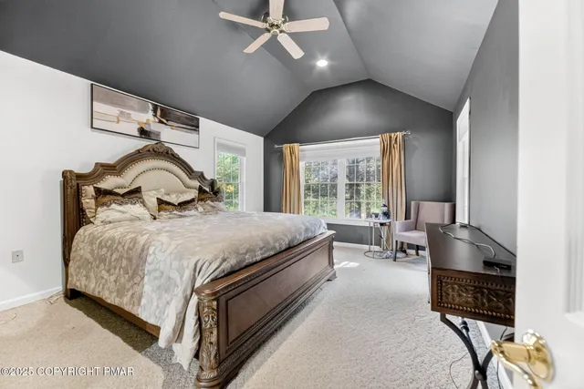 a bedroom with a bed a large window with table and chairs