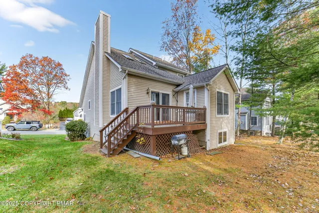 a view of a house with a wooden deck and a yard